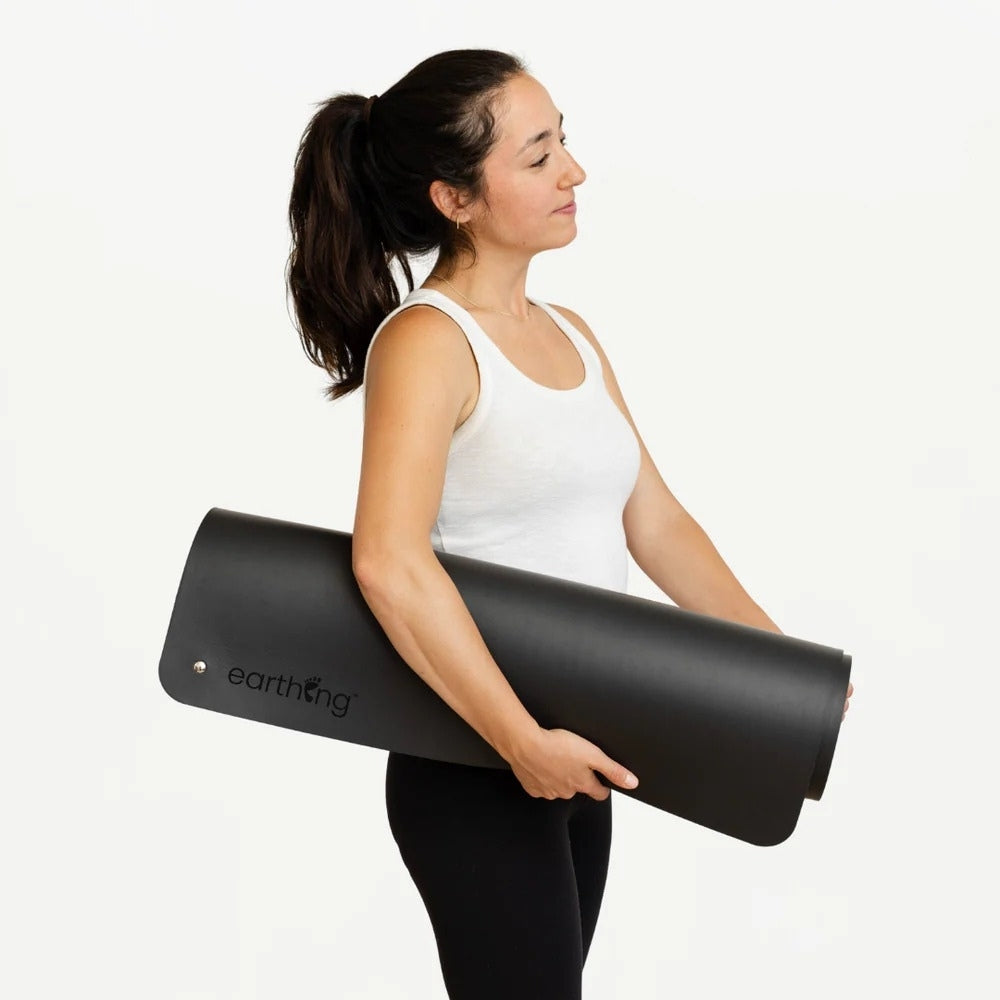 woman holding a grounding yoga mat